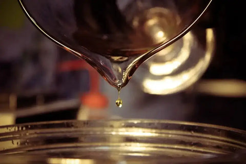 The Vital Role of Bearing Lubrication for Longevity: Oil being poured, showcasing the importance of lubrication in machinery.
