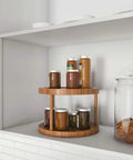 10 inch two tier bamboo lazy susan turntable organizer with jars on display in kitchen shelf.