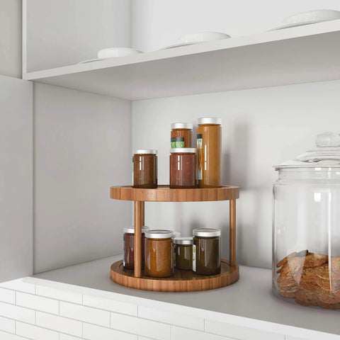 10 inch two tier bamboo lazy susan turntable organizer with jars on display in kitchen shelf.
