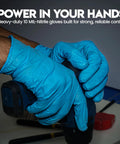Mechanic wearing 10 Mil Nitrile Heavy Duty Gloves With Diamond Grip holding a tool, showcasing textured grip for auto repair.