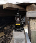 Beefy 10 Ton Hydraulic Bottle Jack For Auto Repair And Home Lifts With Wide Lift Range And Serrated Heat Treated Saddle By Torin Welded Construction Quality installed under wooden frame