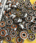 Close-up of 100-Pack Skate Ball Bearings - Nylon Cage - Open showing shiny metal and orange nylon cages.