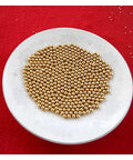 Plate of 100-Pack 3.175mm Ceramic Balls Solid H62 Brass Ball - Precision Smooth Beads Round Balls on red background