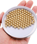 Hand holding 100pcs 6mm Solid Brass Bearing Balls - Industrial Brass Ball Spheres for Machinery, Automotive, and DIY projects.