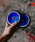 Hand holding two 110mm AIR Scooter Wheels Black Blu Ray Lightweight Durable Pro Scooter Wheels Built for Smooth Control Easy Installation