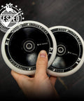 Hand holding two 110mm AIR Scooter Wheels White Black Lightweight Durable Pro Scooter Wheels Built for Smooth Control Easy Installation