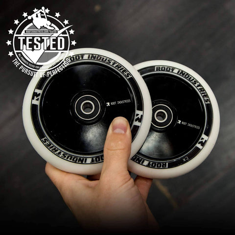 Hand holding two 110mm AIR Scooter Wheels White Black Lightweight Durable Pro Scooter Wheels Built for Smooth Control Easy Installation