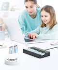 Mother and daughter using a laptop with a 12 Bay Independent Fast Charging Battery Charger For AA AAA 9V NiMH NiCd LCD on the desk