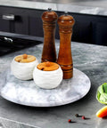 12 inch marble lazy susan turntable made from natural marble, showcasing wood pepper mills and salt cellars.