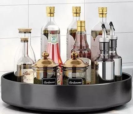 12" inch Stainless Steel Lazy Susan Turntable Organizer displaying bottles and jars in a stylish black tray.