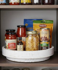 12 Inch Wood Lazy Susan Turntable Organizer For Kitchen Counters And Pantries holding spices and jars on a pantry shelf