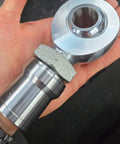 1 1/4 Heim Joints Rod End Kit close-up held in hand, 1.25 Chromoly Joints with Round Tube Adapters and High Misalignment Spacers