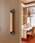 12 Inch Solid Beech Wood Barn Door Handle With Black Metal Brackets Sliding Door Pull For Fence Gate Closet Shed Indoor Handrail And Playground Safety Handles Easy Install Durable And Rust Resistant For Everyday Indoor Or Outdoor Use installed on a wooden door in a dining room.