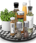 12 Inch Round Black And White Checkered Lazy Susan Turntable with various condiments and plant on kitchen table
