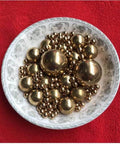 12mm 50pcs Solid Pure Copper Balls - Brass Ball Bead displayed in a decorative dish on a red background
