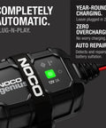 Close-up of NOCO Genius 2A 12V Smart Onboard Battery Charger Maintainer Desulfator With Overcharge Protection, black with green light.