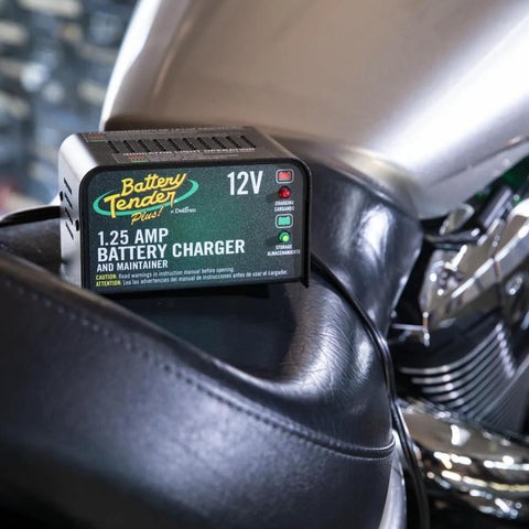 Close-up of 12V 1.25 Amp Car and Motorcycle Battery Charger and Maintainer on a motorcycle seat, showing adaptive smart charging