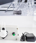 12V Adjustable Peristaltic Dosing Pump Liquid Metering Pump with Adapter for Aquarium Lab Analytical EK1960 beside beakers