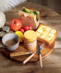 14 inch acacia wood lazy susan cabinet organizer with breakfast items including toast, fruit, and a coffee cup.