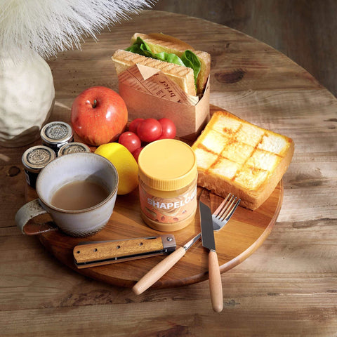 14 inch acacia wood lazy susan cabinet organizer with breakfast items including toast, fruit, and a coffee cup.