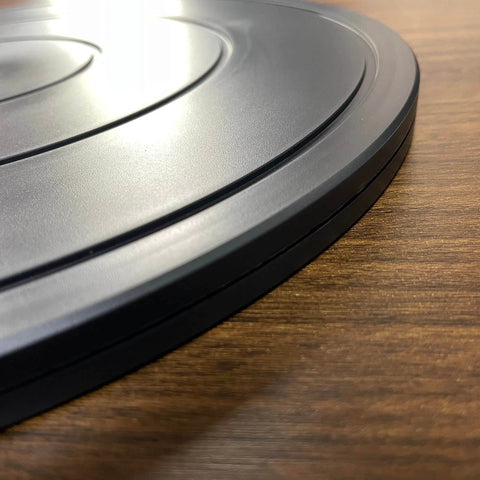 Close-up of black 16 Inch Heavy Duty Rotating Swivel Stand Lazy Susan with Steel Ball Bearings on wooden surface.