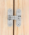 Installed Hidden Door Hinges Set For Cabinets 180 Degree Concealed Cross Hinges on wood surface