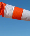 USA Made 18 Inch By 60 Inch Orange And White Nylon Windsock Kit with heavy duty ball bearing frame mounted on a pole against blue sky.