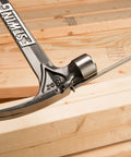 USA-made 19 oz rip claw framing hammer with milled face and shock reduction grip for carpentry, positioned on wooden beams
