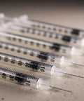 Close-up of 1 mL Syringes With 31G Needle Five Sixteenth Inch Length Individually Wrapped Pack Of 100 For Lab Use