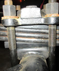Close-up of 2 Inch Wide 4 Degree Steel Leaf Spring Shims for suspension axle, showing black oxidized carbon steel and bolt alignment.