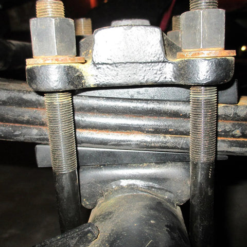 Close-up of 2 Inch Wide 4 Degree Steel Leaf Spring Shims for suspension axle, showing black oxidized carbon steel and bolt alignment.
