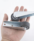 Two Pack Gate Caster Wheels Replacement 1.6 Inch Rubber Rolling Swivel Casters in hand showing steel frame and rubber wheels