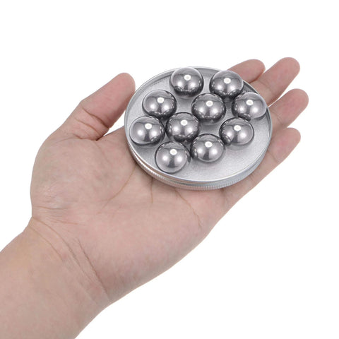 Hand holding a set of 20pcs 20mm Carbon Steel Bearing Balls Precision Polished on a round plate
