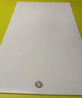 Virgin PTFE Flat Sheet One Eighth Inch Thick By 12 By 24 Inches, nonstick sheet shown with coin for scale, on yellow background