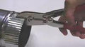 5-Blade Sheet Metal Crimper 9.2 Inch Length used on duct pipe, showcasing hardened alloy steel blades and spring actuated cushioned handle
