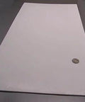 Virgin PTFE Flat Sheet One Eighth Inch Thick By 12 By 24 Inches, shown on table with coin for scale.