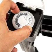 Close-up of Tough As Nails Garden Timer Stake with user setting the timer for automatic operations.