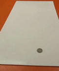 Virgin PTFE Flat Sheet One Eighth Inch Thick By 12 By 24 Inches on red surface, coin for scale; nonstick, chemical resistant material.
