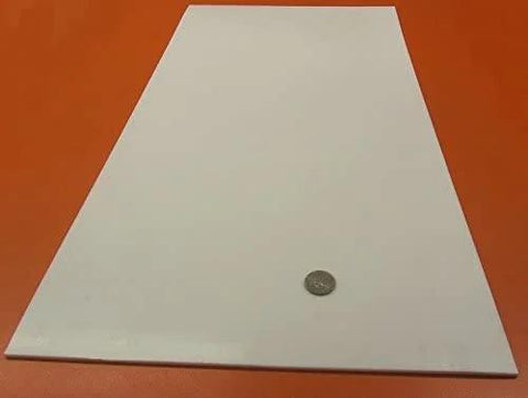 Virgin PTFE Flat Sheet One Eighth Inch Thick By 12 By 24 Inches on red surface, coin for scale; nonstick, chemical resistant material.
