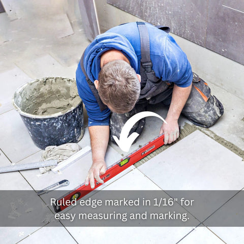 A person using a 24 inch box level with three durable acrylic vials, precise 1/16 inch ruler, wall grip, and hand calibrated straightedge on tiled floor.