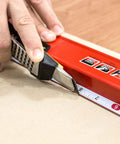 Hand using a 24 inch box level with three durable acrylic vials, precise 1/16 inch ruler, wall grip, and hand calibrated straightedge.