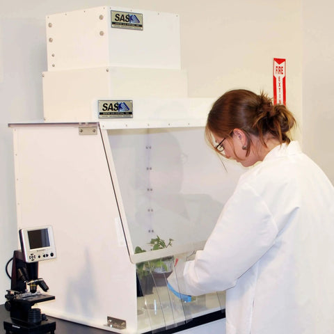 Scientist using 24 Inch Wide Portable Laminar Flow Hood for Medical and Laboratory Use, ISO Class 5 Cleanroom, positive pressure workspace.