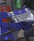 Person operating 24 Inch Box And Pan Sheet Metal Brake With Five Adjustable Fingers for small shops, bending sheet metal in a workshop.