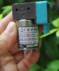 Hand holding 24V Mini Diaphragm Pump, model JYY(B)-Y-10-I with labels, compact design for lab analysis and scientific DIY projects