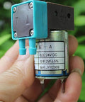 Close-up of a compact 24V Mini Diaphragm Pump, 2W Micro Liquid Water Pump, shown in hand for lab analysis and precise metering.