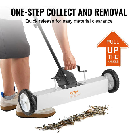 Effortless, heavy duty rolling magnetic sweeper with a 24 inch wide magnet and 50 lb pickup capacity in use on a workshop floor.