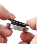 Close-up of hands holding Two Pack Black Axle Protection Covers for Bike Bearings Dust Covers, showing installation.