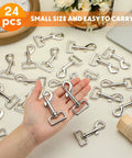 Hand holding 24 Pack Swivel Snap Hooks For Dog Leashes Heavy Duty 2.76 Inch Flag Clasp Clip Hooks displayed on table.