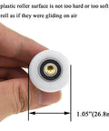 Close-up of 27mm diameter brass shower door wheels with nylon rollers and ball bearings, held in hand for size comparison.