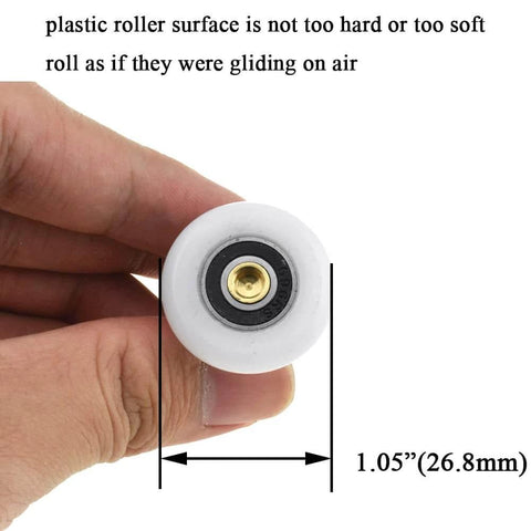Close-up of 27mm diameter brass shower door wheels with nylon rollers and ball bearings, held in hand for size comparison.